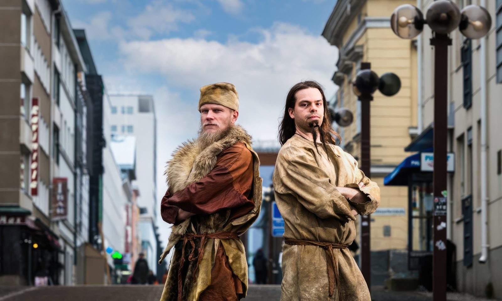 Kaksi kivikauden tyyliin nahkapukuihin pukeutunutta henkilöä seisoo Oulun keskustassa.
