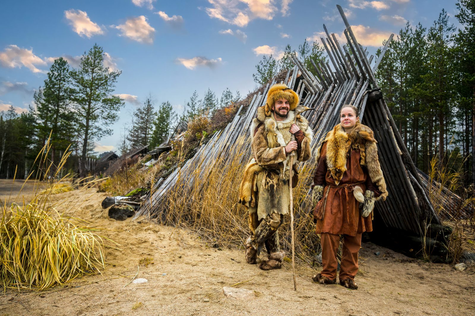 Workers in Stone Age costumes standing in front of the dwelling.