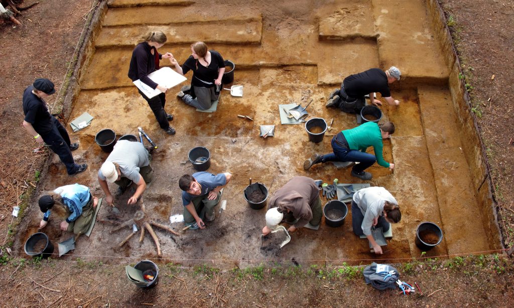 A dwelling depression is being excavated in sections during the public excavations at Kierikinkangas. The centre of the dwelling depression is in the lower left corner.