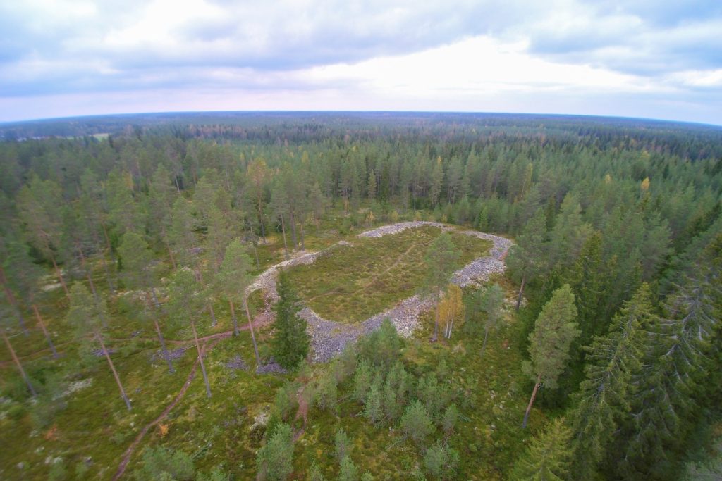 Ilmakuvassa metsän keskellä kivien muodostama rengasmainen kuvio.